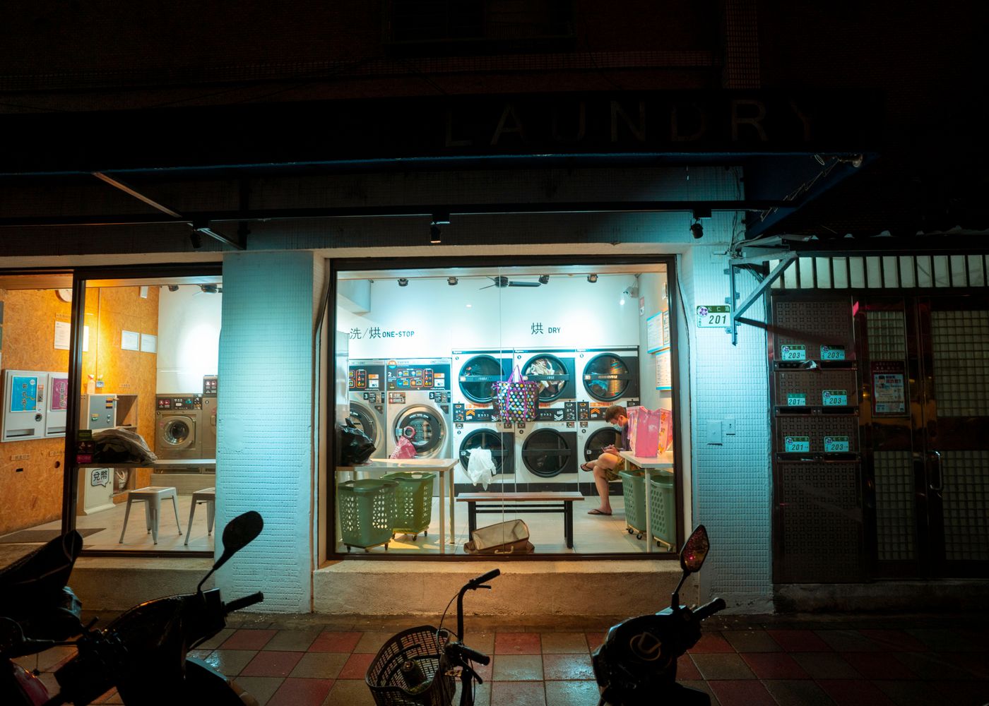 A warm, modern London launderette at night